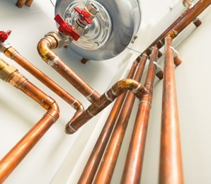 A heating unit with many pipes coming off it.